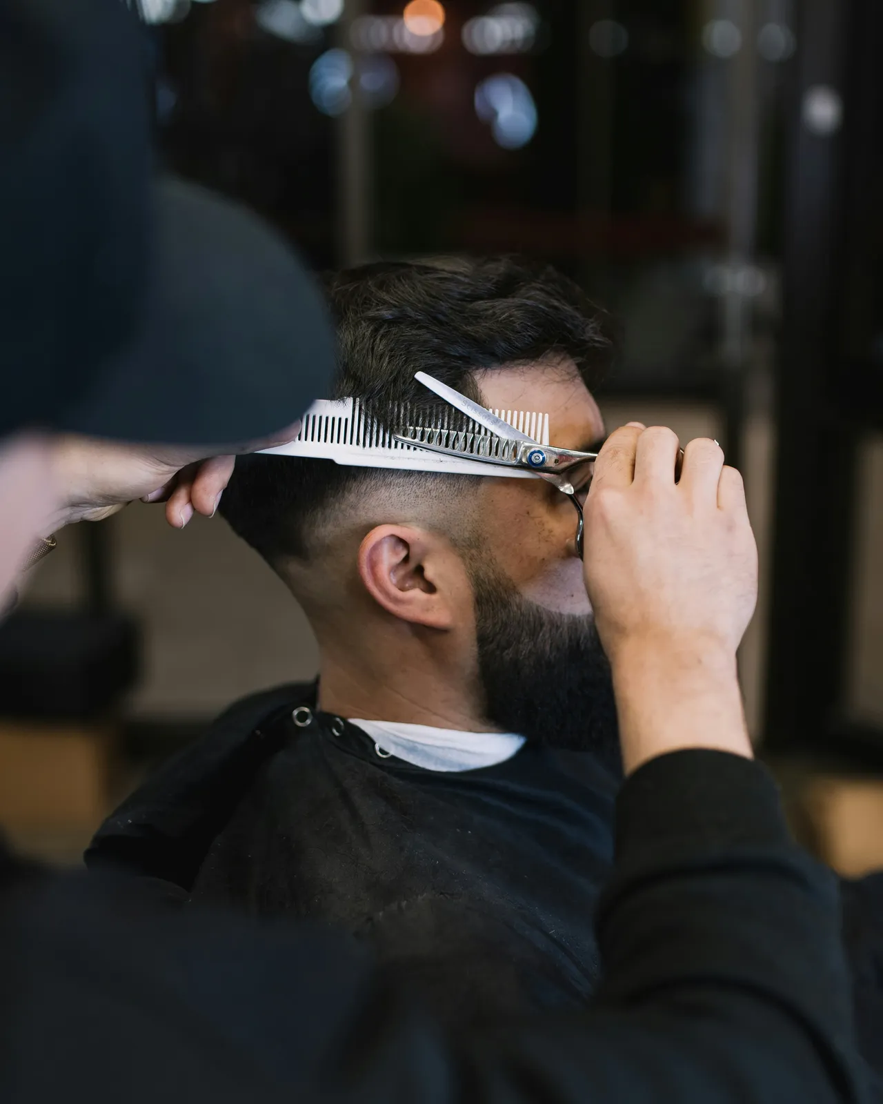 Empty barber chairs in front of lit mirrors, waiting for the next client