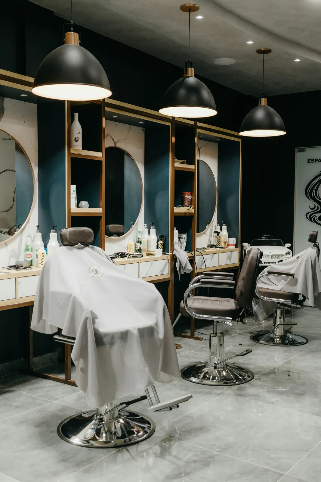 A barber shaping a client's beard in the chair