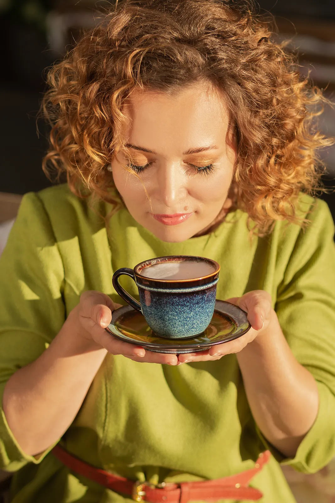 A loyalty card held over a takeaway coffee cup at the counter