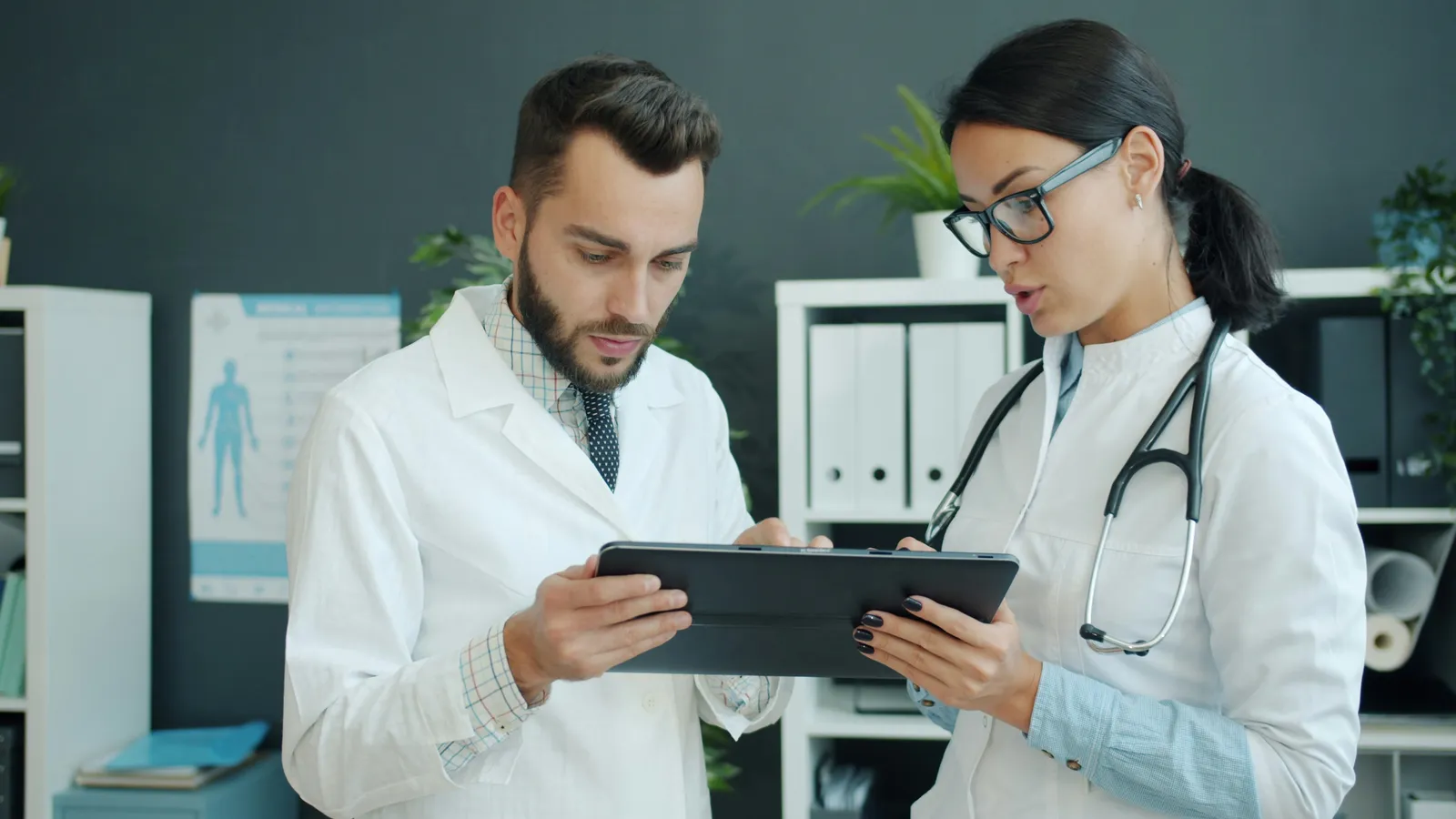 A doctor at a desk talking with a patient