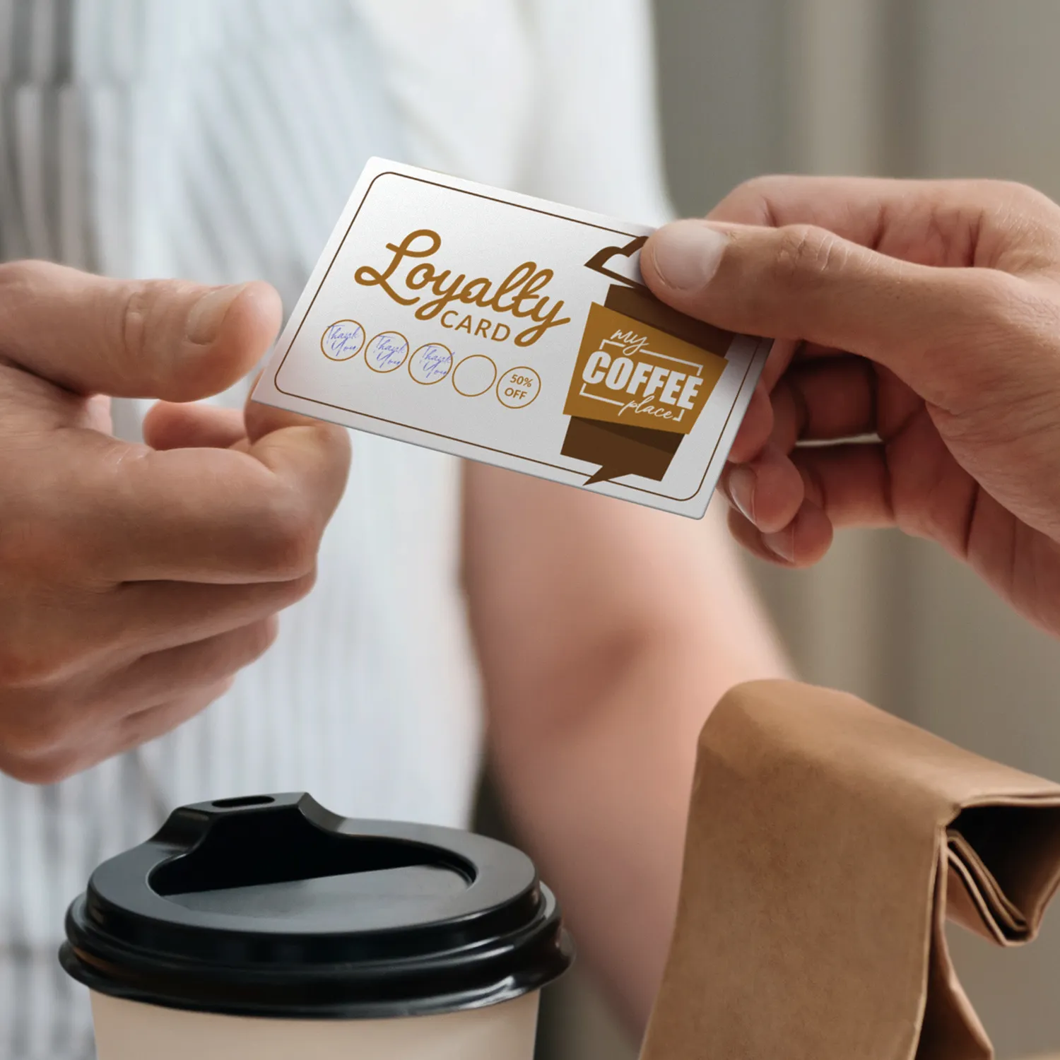 A loyalty card held over a takeaway coffee cup at the counter