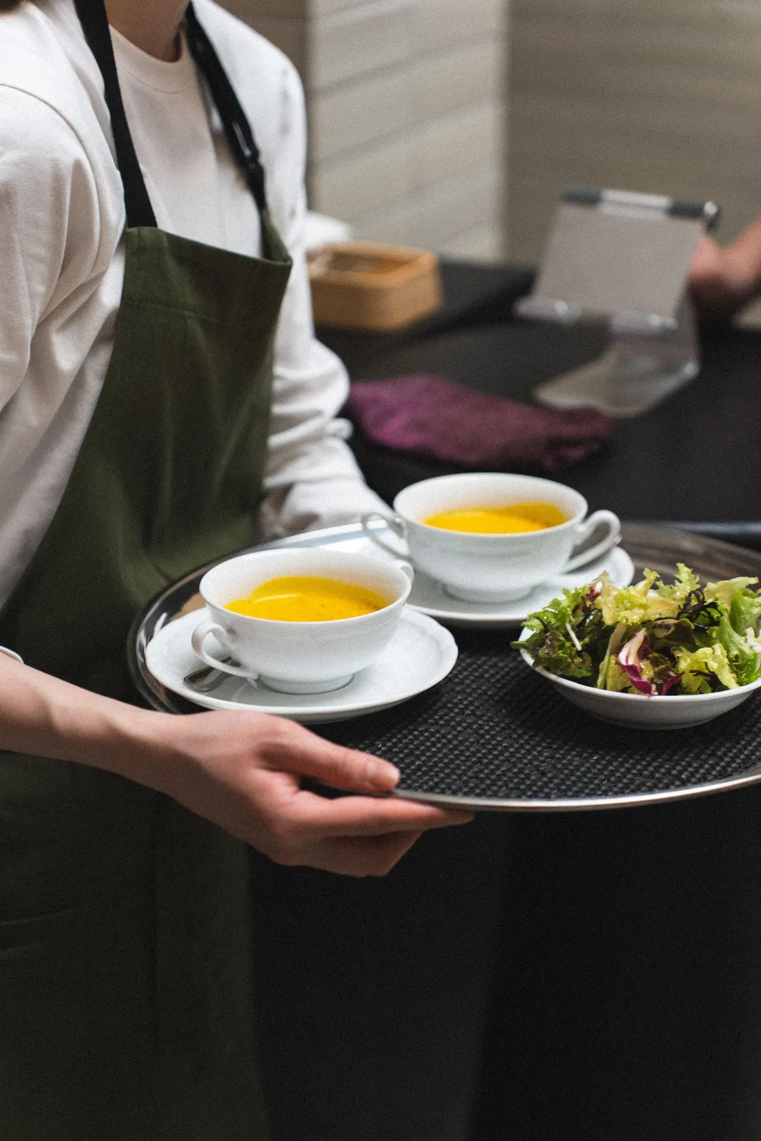 A waiter handing a card terminal to a guest at the end of a meal